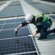 Worker installing solar panels on roof